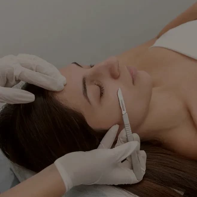 A dermaplaning blade held flat against the skin