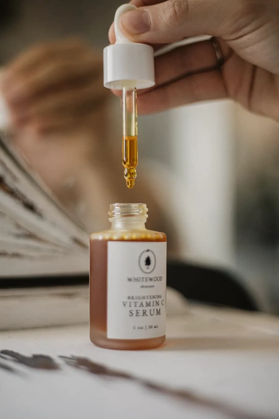 A dropper of serum held over its bottle