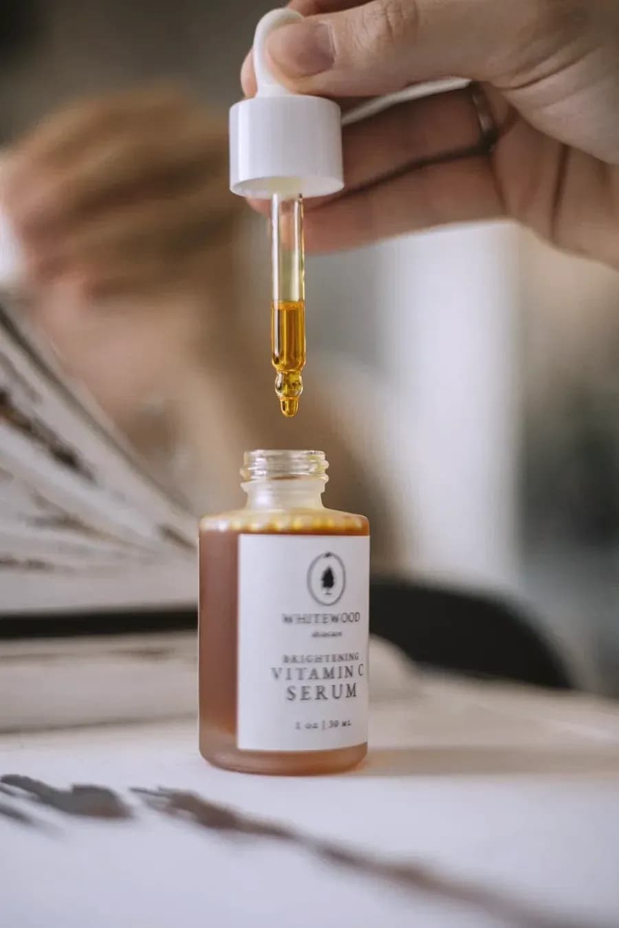 A dropper of serum held over its bottle